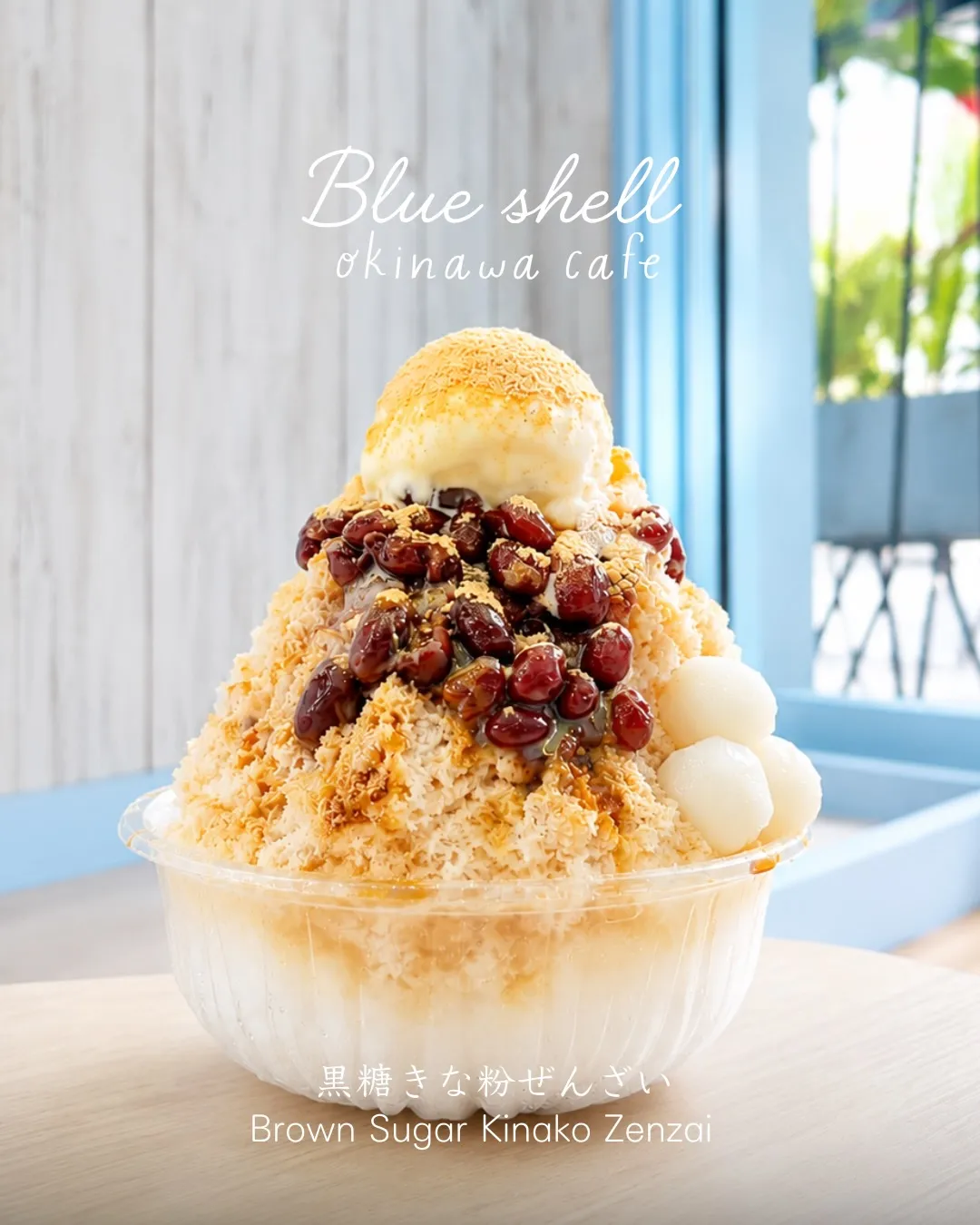 透明なカップに盛られたアイスや小豆、白玉がトッピングされたかき氷。「Blue shell okinawa cafe」「黒糖きな粉ぜんざい Brown Sugar Kinako Zenzai」の文字入り。