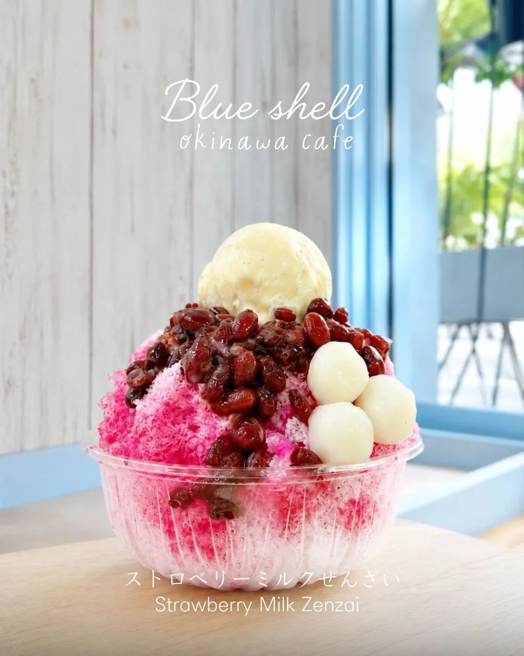 「Blue shell okinawa cafe」の文字とともに、透明カップに盛られた「ストロベリーミルクぜんざい Strawberry Milk Zenzai」。ピンク色のイチゴかき氷の上に小豆、3つの白玉、アイスクリームがトッピングされている。